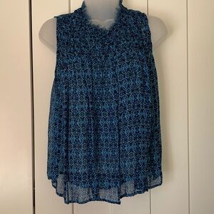 Gauzy A sleeveless blouse with smocked bodice and raw edge collar.